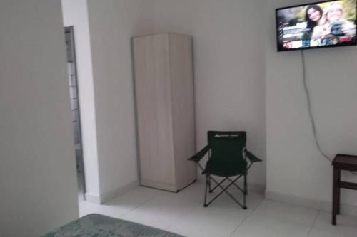 a green chair sitting in a room with a wall at Departamento en Villa Elisa. in Villa Elisa