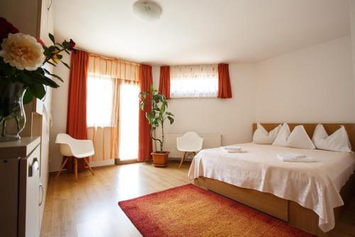 a bedroom with a white bed and a vase of flowers at Charming Villa in a Private Mountain Resort in Braşov