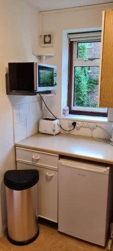 a kitchen with a counter with a phone and a window at Studio Garden Flat in Warlingham
