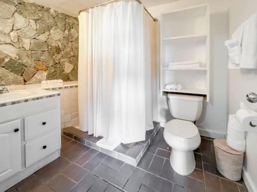 a bathroom with a toilet and a shower curtain at Ocean View Retreat Villa in Enighed