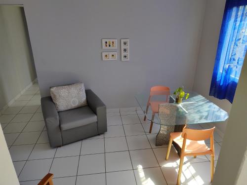 a living room with a chair and a table at Ed Bertholi - Vista lateral do mar com garagem in Serra