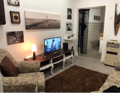 a living room with a television on a table at Grandma`s house in Lisbon in Odivelas