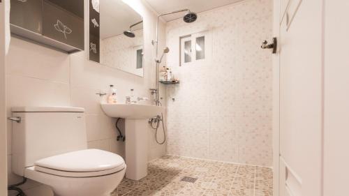 Un baño blanco con inodoro y lavabo. en Tinkerbell detached house, en Gyeongju