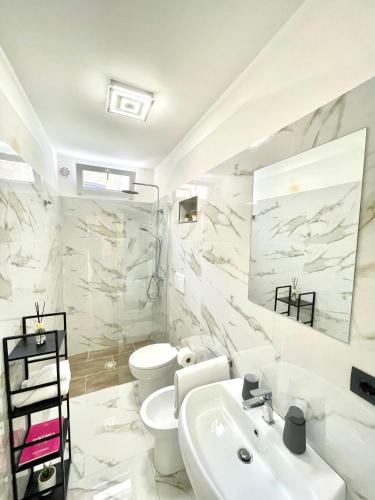 a white bathroom with a sink and a toilet at Vohis Luxury House - Fast Wi-fi & Easy parking in Lecce