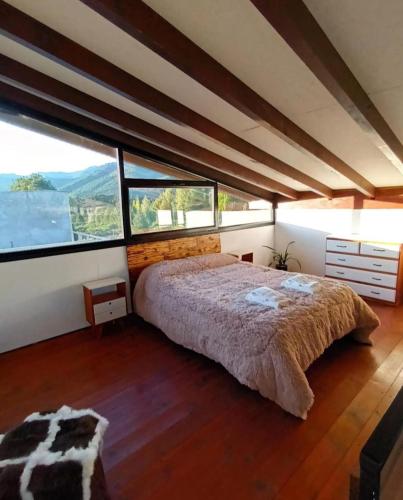 維亞梅立奎納的住宿－Cabañas Abedul，一间卧室设有一张大床和大窗户