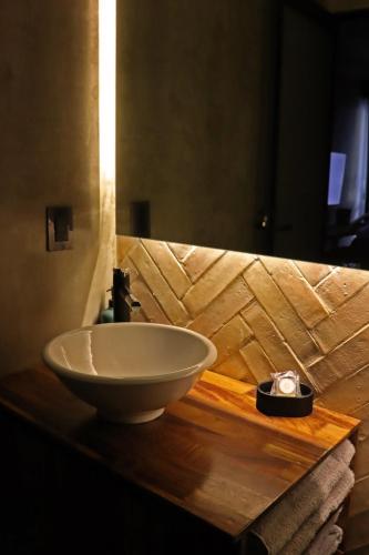 a bathroom with a bowl sink on a wooden counter at Layoo, Tu casa en Oaxaca 102 in Oaxaca City