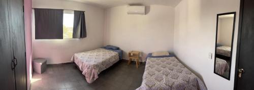 ein kleines Zimmer mit 2 Betten und einem Fenster in der Unterkunft Casa Carlota Mazatlán in Mazatlán