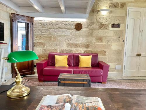 - un canapé violet avec des oreillers jaunes dans le salon dans l'établissement Vohis Luxury House - Fast Wi-fi & Easy parking, à Lecce