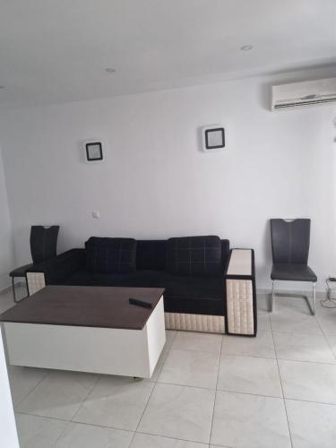 sala de estar con sofá negro y 2 sillas en Maria Residence 2B, en Costinesti