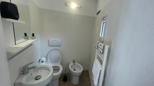 La salle de bains blanche est pourvue de toilettes et d'un lavabo. dans l'établissement APPARTAMENTI ALBANI, à Maglie