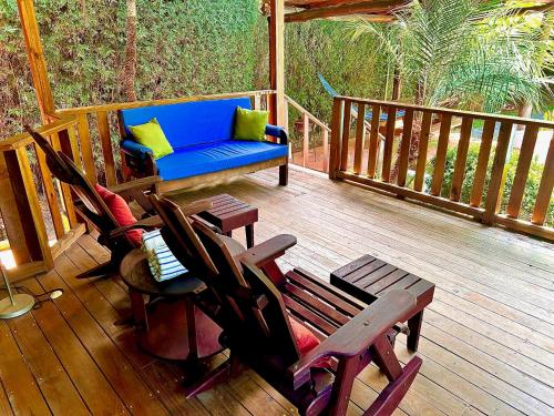 - une terrasse couverte avec des chaises et un canapé bleu sur la terrasse dans l'établissement Ocean Melody, à Uvita