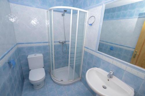 uma casa de banho com um chuveiro, um WC e um lavatório. em Sotogrande. Estancia privada en plena naturaleza em Sotogrande