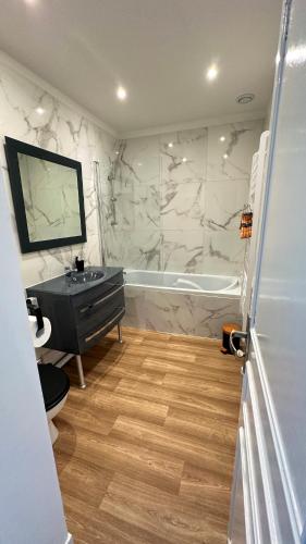 une salle de bain avec un lavabo et une baignoire dans l'établissement L’appartement du vieux bassin, à Honfleur