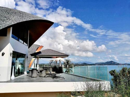 a house with a deck with a view of the water at 苏梅岛观景台海景別墅Golden Coconut Villa 5 超级海景 私密泳池 接送服务 in Koh Samui 