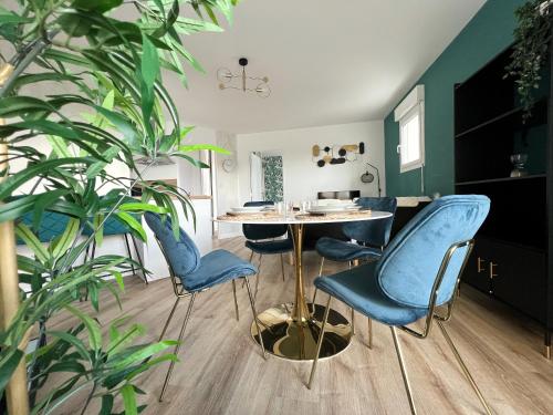 ein Esszimmer mit blauen Stühlen und einem Tisch in der Unterkunft Le Saphir in Rezé