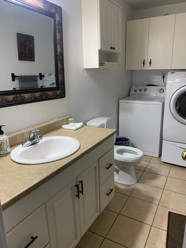 a bathroom with a sink and a washing machine at Entire 2-bedroom bungalow in Cornwall