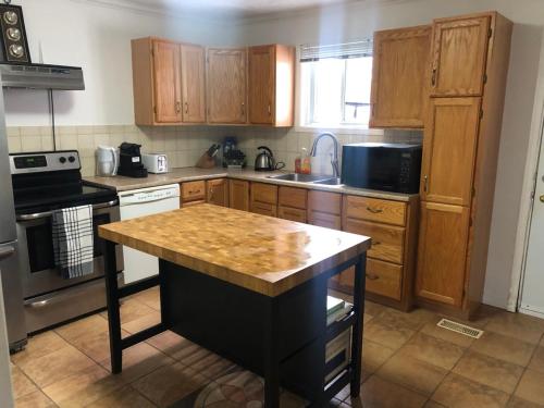 a kitchen with wooden cabinets and a wooden counter top at Entire 2-bedroom bungalow in Cornwall