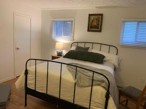 ein Schlafzimmer mit einem Bett und einem Tisch mit einer Lampe in der Unterkunft Entire 2-bedroom bungalow in Cornwall