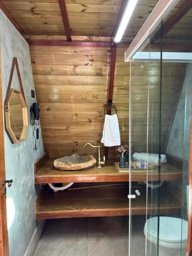 a bathroom with a sink and a glass shower at Chalés Mirante da Serra PB in Serra da Raiz