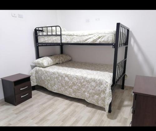 a bedroom with two bunk beds and a night stand at Acogedor apartamento en la ciudad de las araucarias in Santa Rosa de Cabal