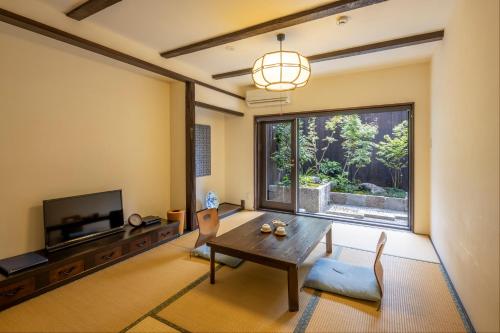 Machiya Oozora في كيوتو: غرفة معيشة مع طاولة ونافذة كبيرة