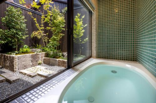 a bath tub in a bathroom with a window at Machiya Oozora in Kyoto
