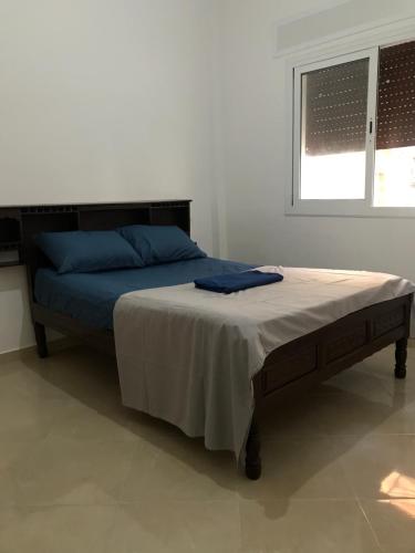 a bedroom with a bed with blue pillows and a window at Spacious 2-rooms apartment in Martil