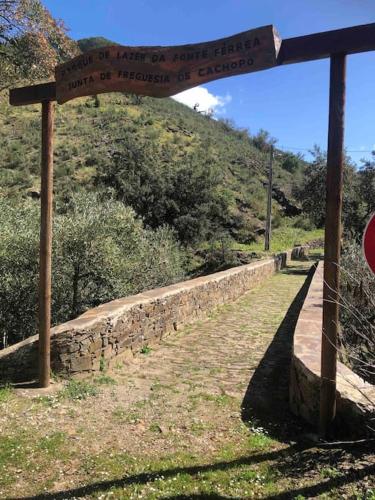 a sign on a stone wall next to a hill at Casa Tranquila Barrada in Alcoutim