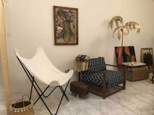 uma sala de estar com uma cadeira branca e uma cadeira em Casa Tranquila Barrada em Alcoutim