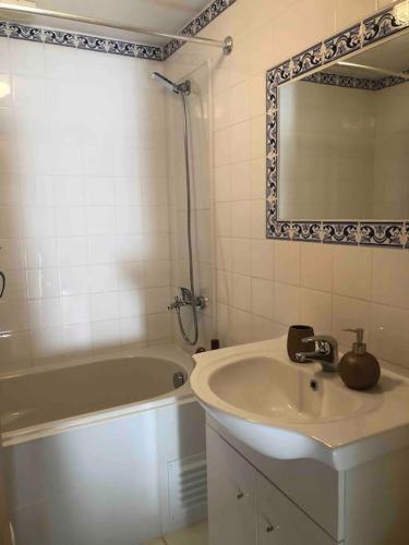 a bathroom with a sink and a tub and a mirror at Casa Tranquila Barrada in Alcoutim
