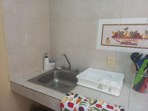 um balcão de cozinha com um lavatório e uma taça de fruta em Agradable y cómodo departamento a 5 minutos del aeropuerto em Cidade do México