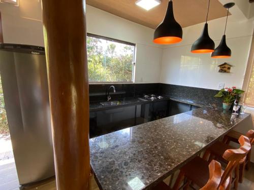 a kitchen with a black counter top and a sink at Casa.dovale in Caeté-Açu