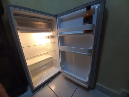 an open refrigerator with a bottle of beer in it at Agradable y cómodo departamento a 5 minutos del aeropuerto in Mexico City