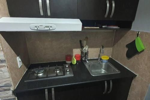 a small kitchen with a sink and a stove at R.1108 Lindo aparta estudio equipado tipo ejecutivo. in Panama City