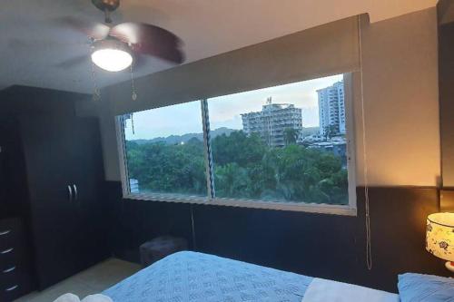 a bedroom with a window with a view of a city at R.1108 Lindo aparta estudio equipado tipo ejecutivo. in Panama City