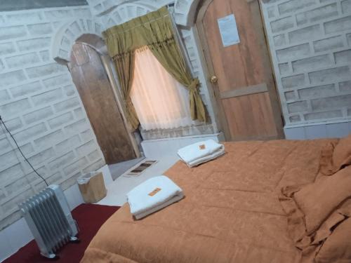 Hostal Cabaña Blanca : غرفة نوم عليها سرير وفوط