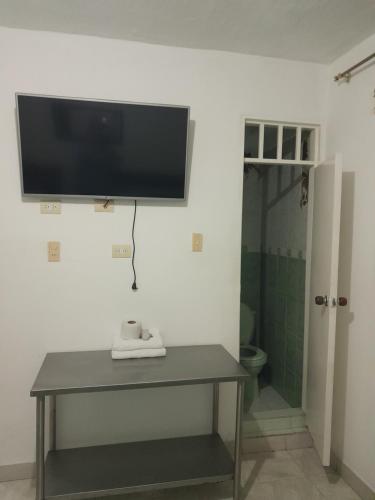 a television on the wall of a bathroom with a table at HOTEL CASA BLANCA in Popayan