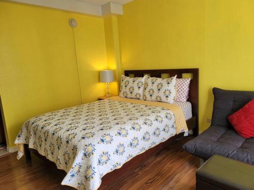 a yellow bedroom with a bed and a couch at Waikiki condo -18F in Honolulu