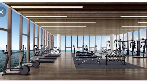 une salle de sport avec une rangée de tapis de course et de machines dans l'établissement Mutiara Bali Residence Melaka, à Malacca