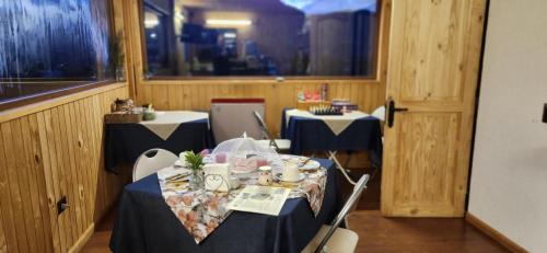 un comedor con 2 mesas con mantel azul y blanco en Hostal Hunter en Puerto Montt