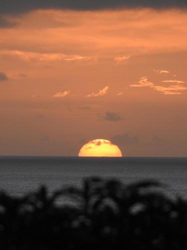 a sunset over the ocean with the sun in the horizon at Fare Mirimiri in Uturoa