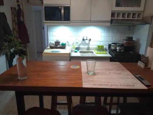 una cocina con una mesa de madera con un cartel. en Departamento Guemes en Mar del Plata