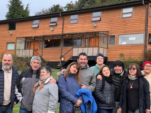 a group of people standing in front of a house at Hostal Hunter in Puerto Montt