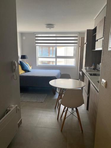 a small room with a small table and a kitchen at Apart Center Temuco in Temuco