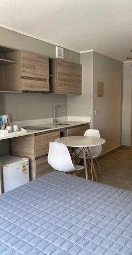 a kitchen with a table and chairs and a sink at Apart Center Temuco in Temuco