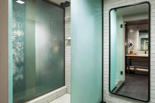 a glass shower in a bathroom with a mirror at Renaissance Minneapolis Hotel, The Depot in Minneapolis