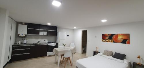 um quarto com uma cama e uma cozinha com uma mesa em Plaza Urbana 2 I em Mar del Plata