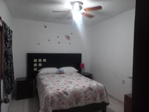 een slaapkamer met een bed en een plafondventilator bij Cómodo & confortable apartamento. 5 minutos del aeropuerto in Mexico-Stad