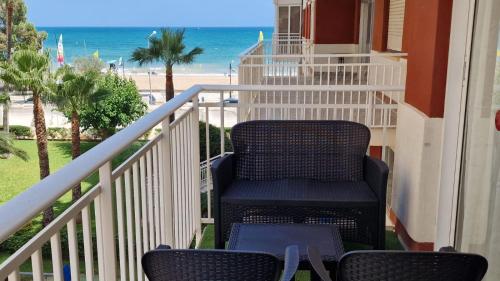a chair on a balcony with a view of the beach at Perfect direct beach access in Benicàssim