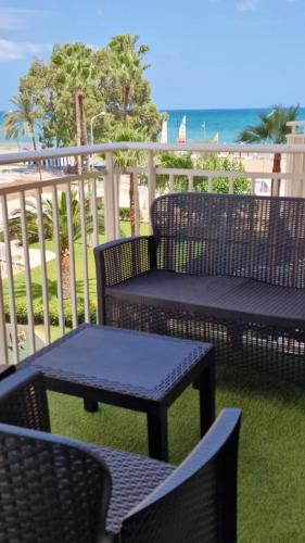 a patio with chairs and tables and the beach at Perfect direct beach access in Benicàssim